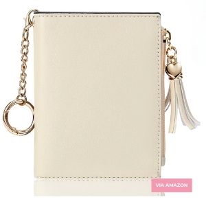 Beige wallet with a gold keychain, heart-shaped charm, and tassel detail, displayed against a white background.